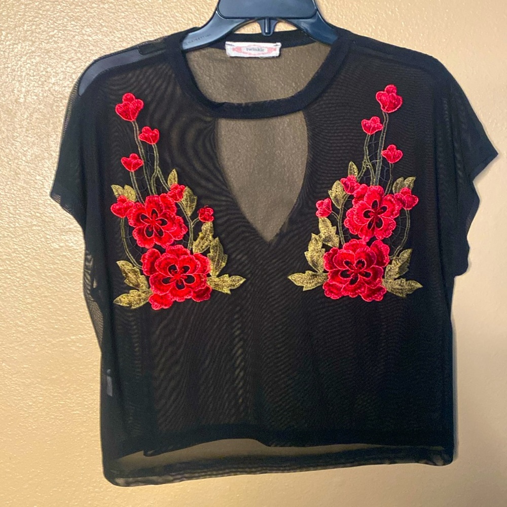 Very sheer top with beautiful floral appliqué. Choker style neckline. Size M.